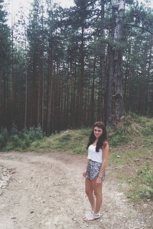 tree, forest, lifestyles, casual clothing, leisure activity, young adult, person, full length, standing, front view, young women, portrait, looking at camera, tree trunk, woodland, nature, day, outdoors