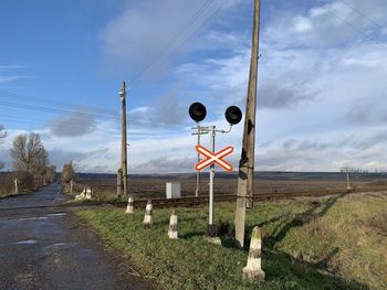 Road signs on field against sky