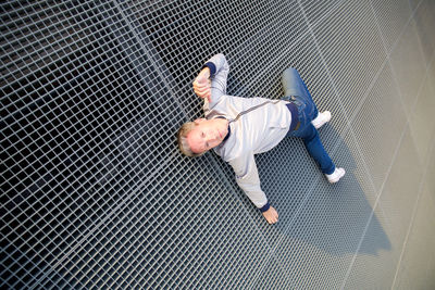 High angle view of woman lying down on metal