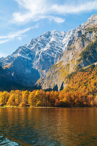 Scenic view of lake by mountains against sky