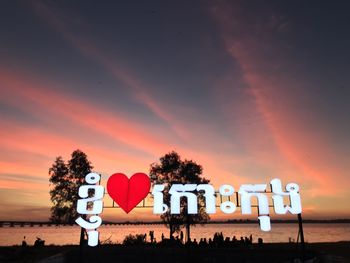 Road sign against sky during sunset