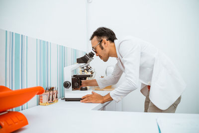 Side view of doctor examining patient in clinic