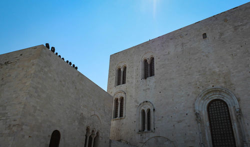 Low angle view of old building against clear blue sky