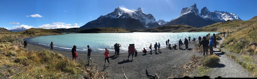 Panoramic view of people on shore against sky