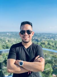 Portrait of young man wearing sunglasses against sea