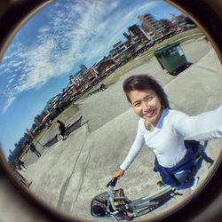 Smiling woman riding motorcycle against sky