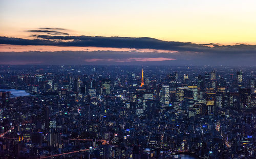 High angle view of city lit up at sunset