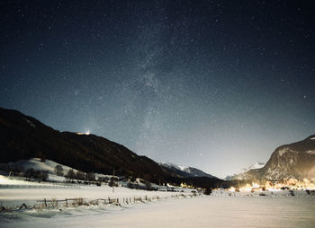 Scenic view of snow covered land against sky at night