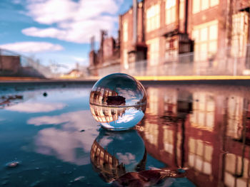 Surface level of crystal ball in water against building