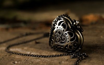 Close-up of chain with heart shape pendant on wooden table