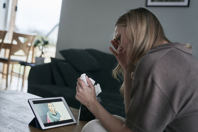 Worried woman doing video call on tablet pc