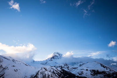 Scenic view of snowcapped mountains against blue sky