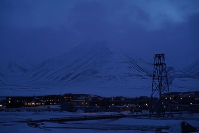 Snow covered mountain against sky at night