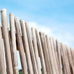 Low angle view of wooden fence against sky