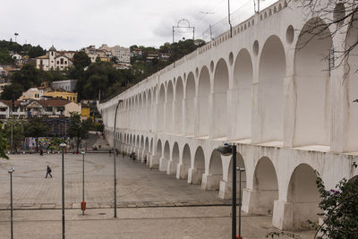 Arch bridge in city against sky