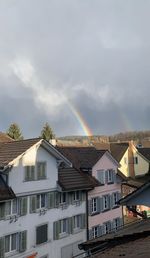 Low angle view of rainbow over buildings in city
