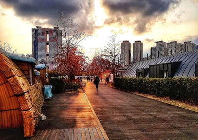 Man walking on city against sky