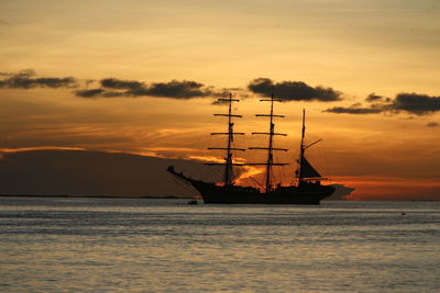 Silhouette ship on sea against sky during sunset