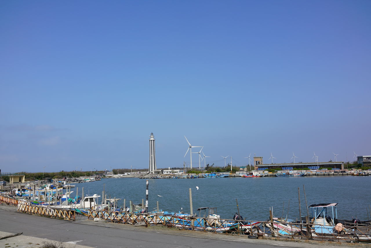 SAILBOATS MOORED AT HARBOR AGAINST SKY