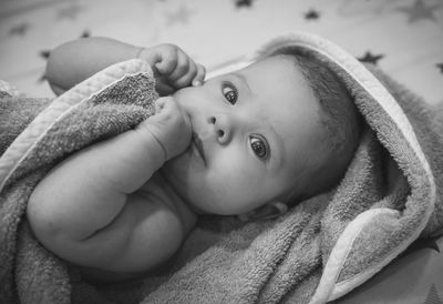 Close-up of cute baby boy lying on bed at home