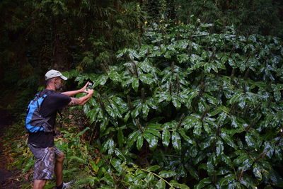 Man photographing against trees