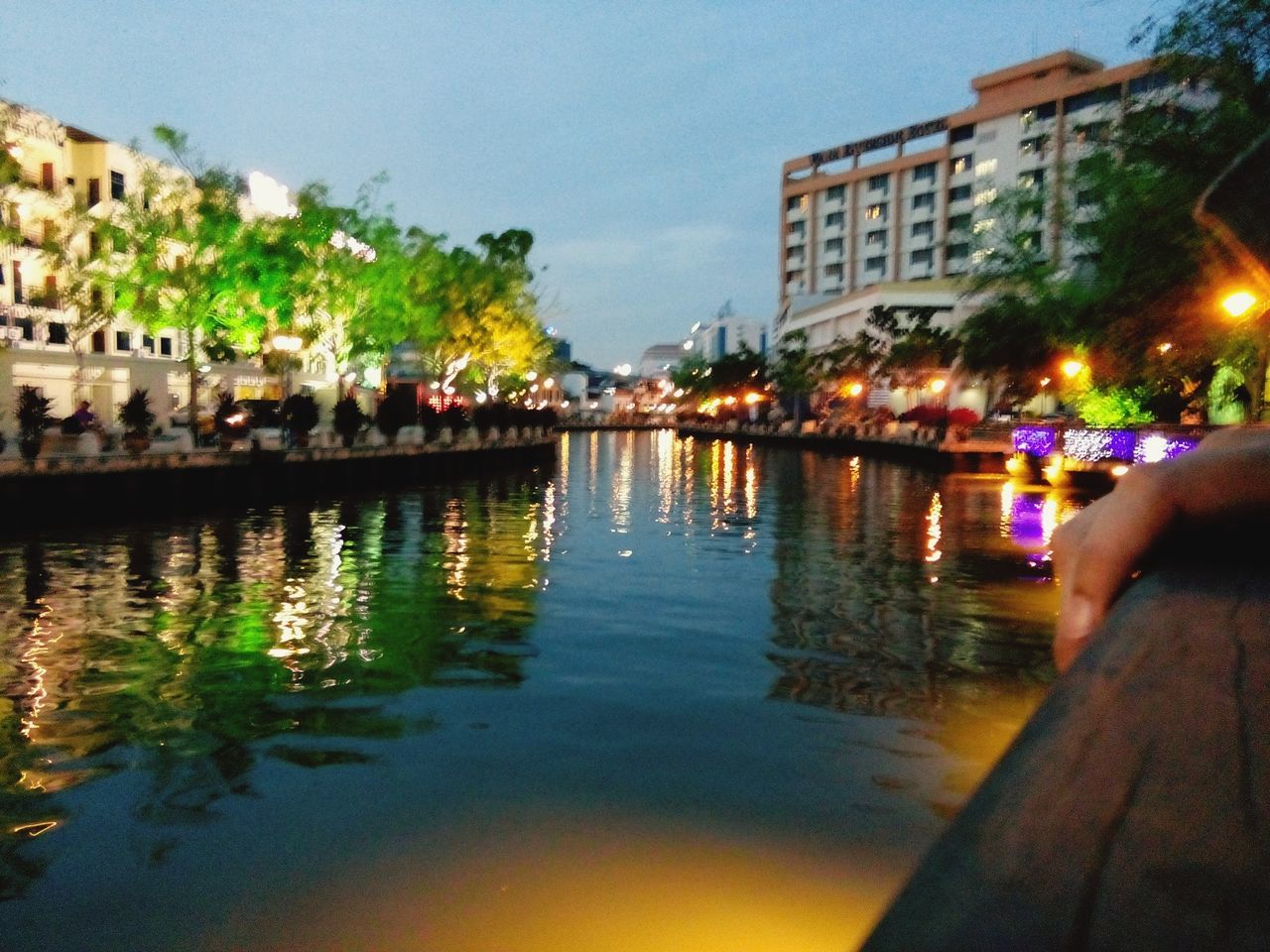 building exterior, water, architecture, illuminated, built structure, reflection, city, night, waterfront, canal, sky, city life, incidental people, street, transportation, residential building, outdoors, residential structure, tree