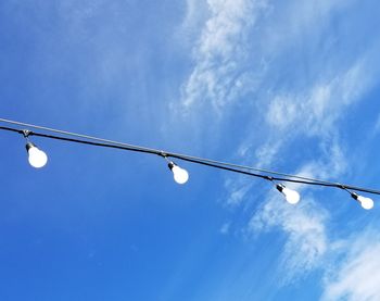 Low angle view of street light against blue sky