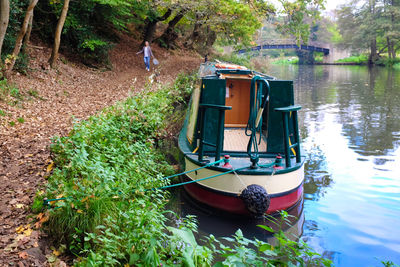 Boat moored on river amidst trees in forest