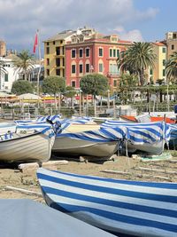 Boats moored in city against sky