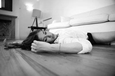 Beautiful woman resting on hardwood floor at home