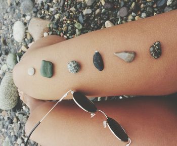 Low section of woman with stones on bare legs