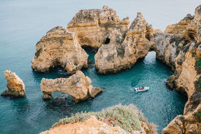 High angle view of rock formation in sea against sky