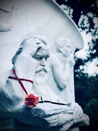 Close-up of statue against white flowers