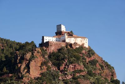 Low angle view of buildings against clear blue sky