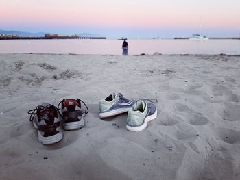 High angle view of shoes on beach against sky during sunset