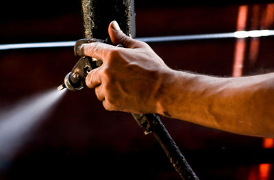 Cropped hand of man spraying water using machinery