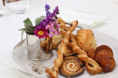 High angle view of breads and pastries with flower vase in tray