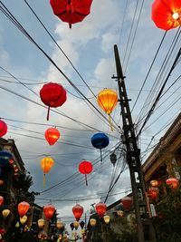 Low angle view of lanterns hanging against sky