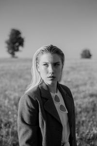 Portrait of young woman standing on field