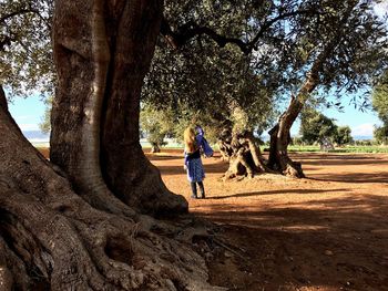 Full length of woman standing by tree against sky