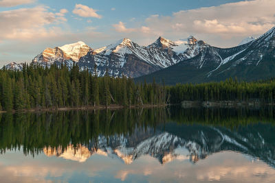 Scenic view of lake by snowcapped mountains against sky