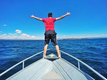 Rear view of man standing on boat