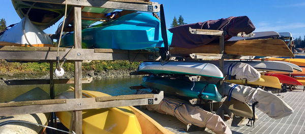 Boats moored in lake against blue sky