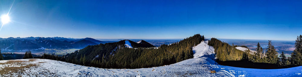 Panoramic view of snowcapped mountains against blue sky