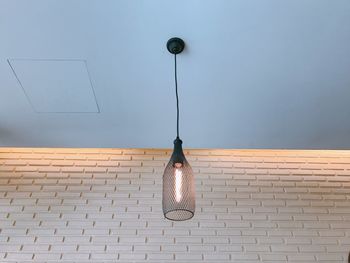 Low angle view of pendant light hanging on wall