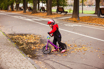 Boy riding bicycle on footpath