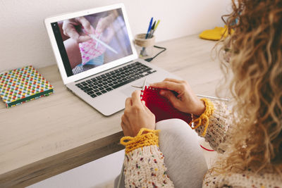 Midsection of woman using laptop on table