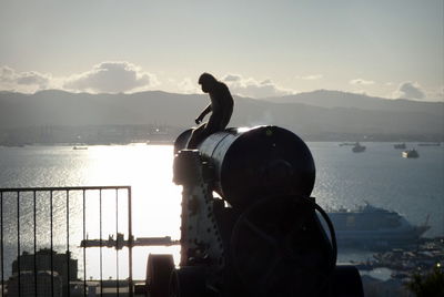 Man standing by railing against sea