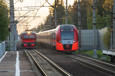 Russian old commuter and high-speed electric train on railroad at station