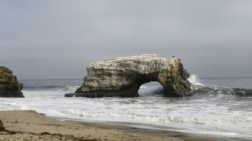 Scenic view of sea stack against sky